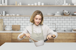 A woman in a kitchen preparing food on a counter