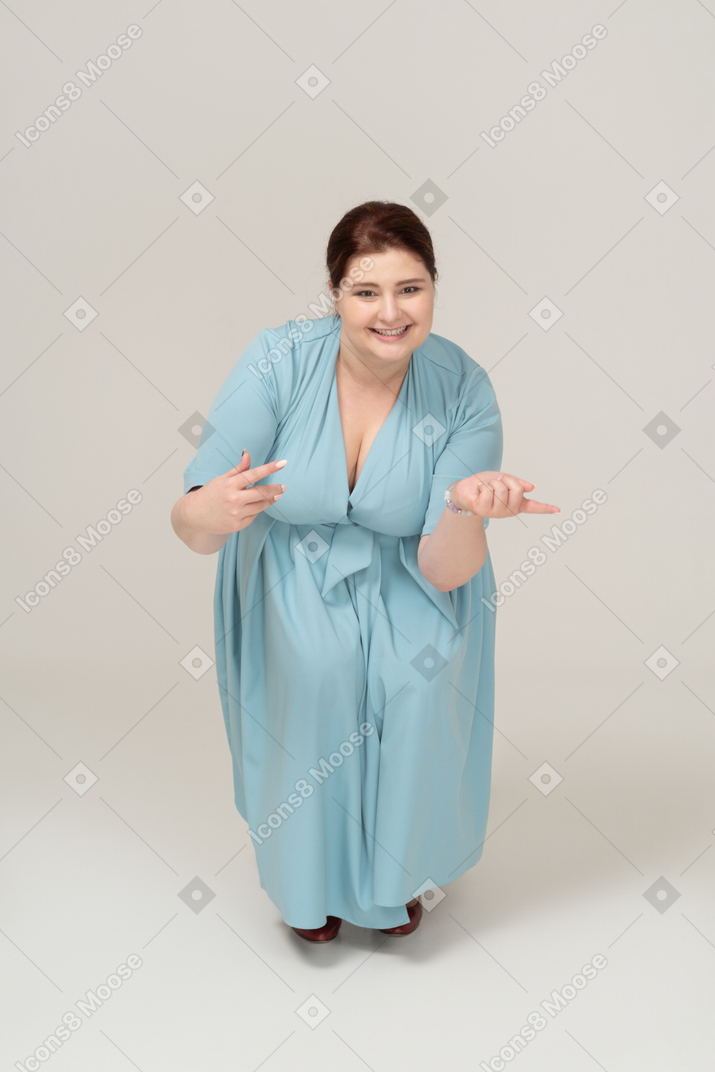 Vista frontal de uma mulher de vestido azul agachada