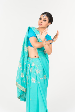 Jeune femme indienne en sari bleu debout en position de danse