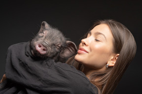 Hermosa chica con cerdo en miniatura