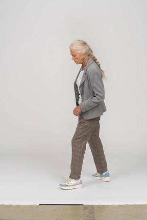 Side view of an old lady in suit walking