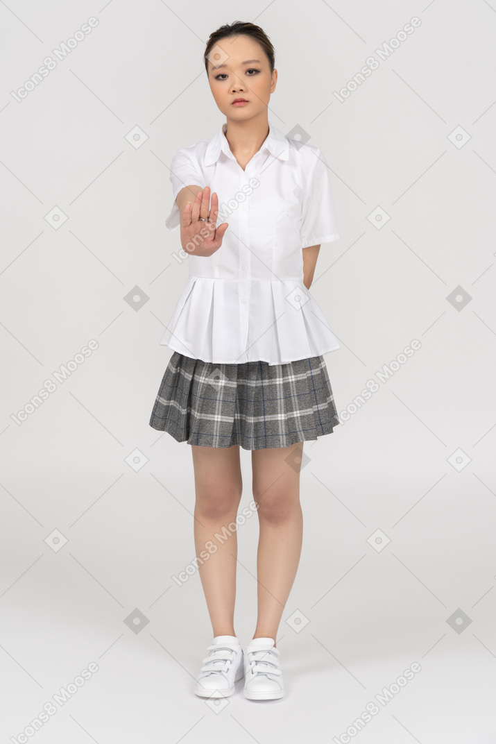 Menina asiática séria, fazendo um gesto de parada