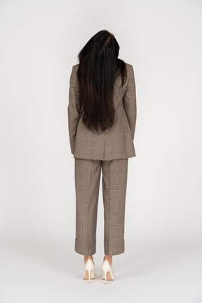 Back view of a young lady in brown business suit leaning back