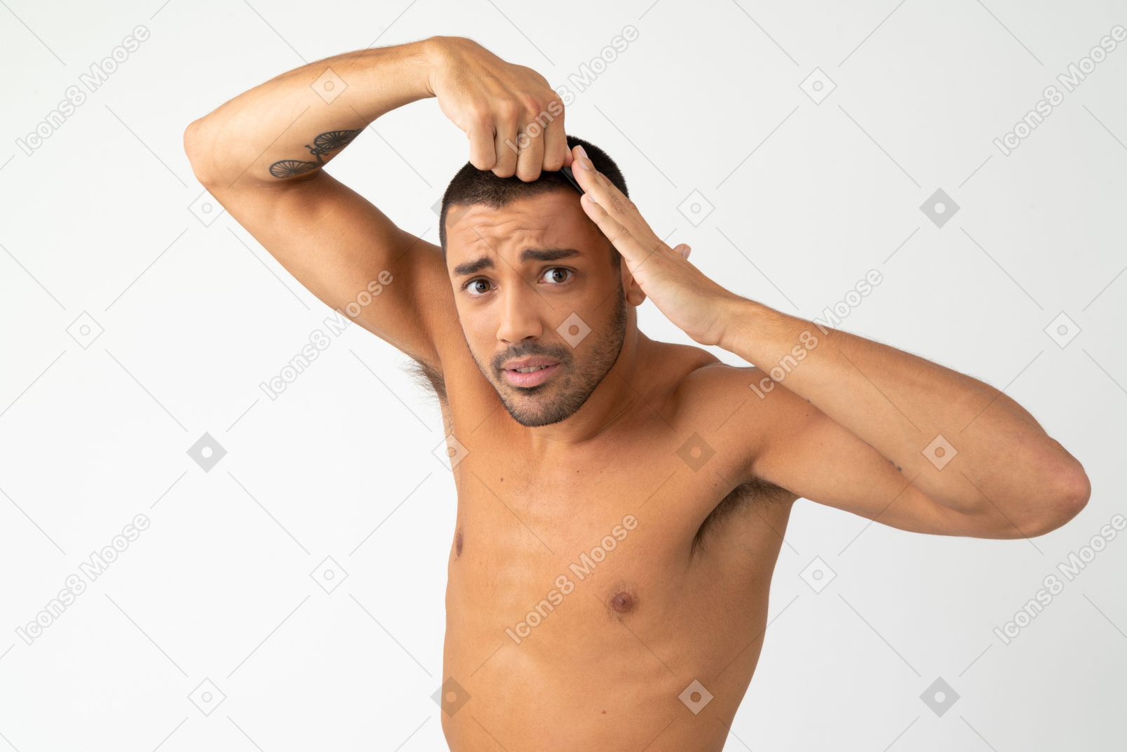 Verwirrter junger mann mit nacktem oberkörper, der sein haar berührt