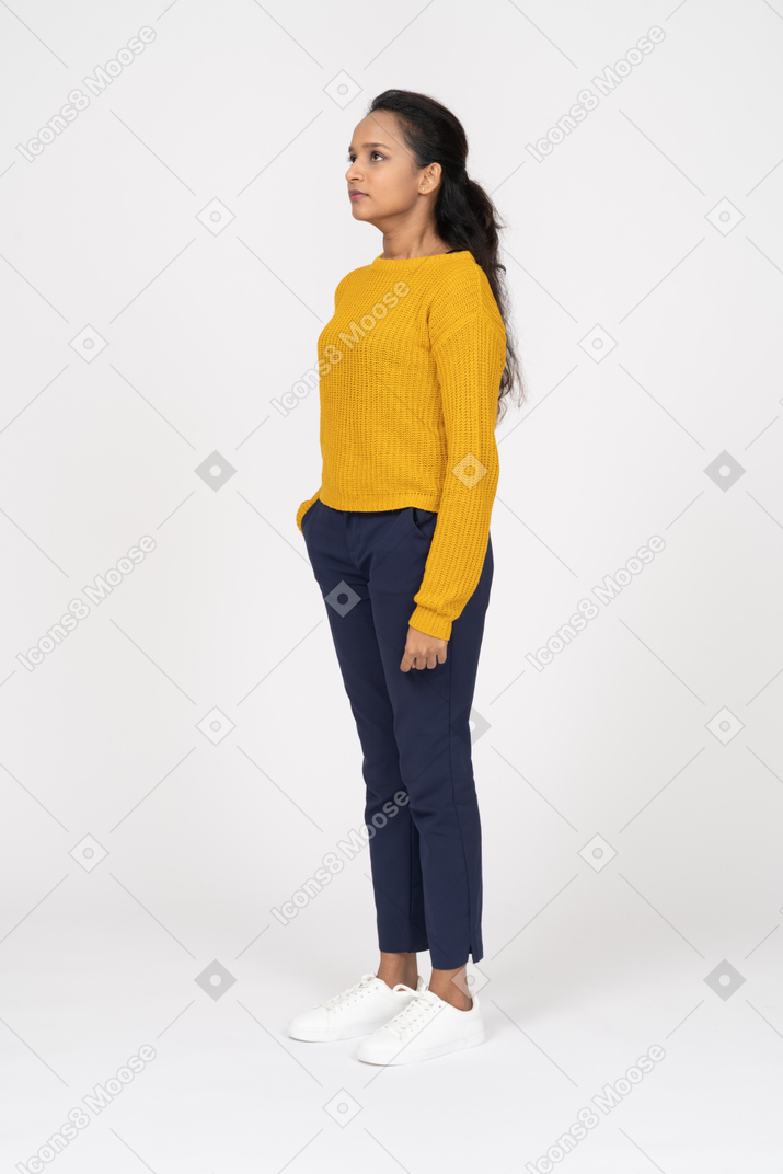 Side view of a girl in casual clothes standing with hand in pocket