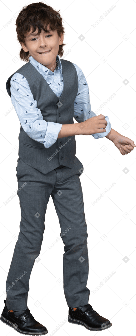Front view of a cute boy in grey suit dancing and looking at camera
