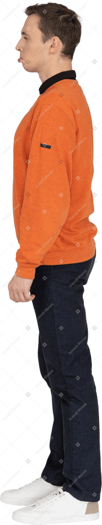 Young man in orange sweatshirt standing