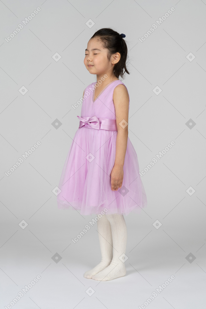 핑크 드레스를 입은 어린 소녀는 눈을 감고