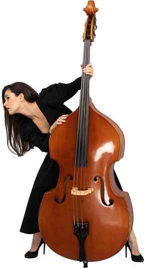 Front view of a young lady standing behind her double-bass while leaning aside