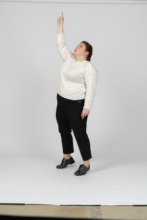 Vue de face d'une femme de taille plus dans des vêtements décontractés debout avec le bras levé