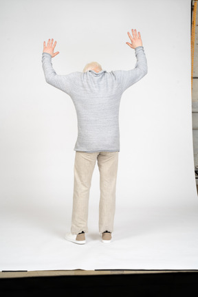 Homme debout avec les bras levés et dos à la caméra