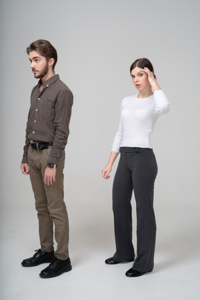 Longitud total de un hombre joven en ropa de oficina y una mujer joven tocando la cabeza