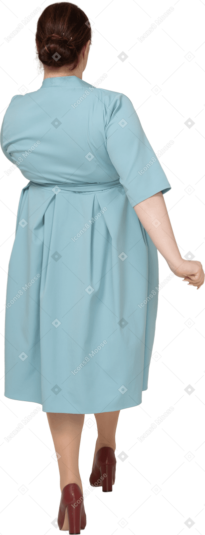 Вид сзади женщины в синем платье на прогулке