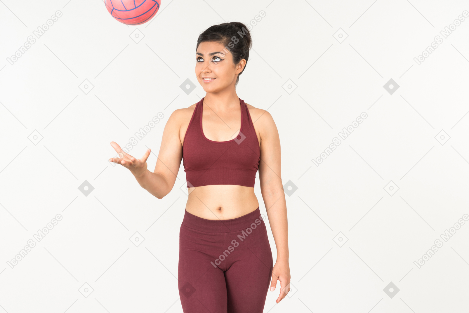 Молодая индийская женщина в спортивном костюме, бросая мяч