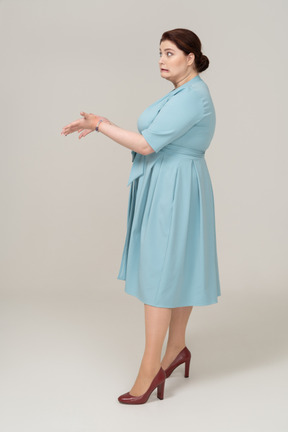 Side view of a woman in blue dress making faces