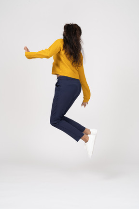 Вид сбоку на девушку в повседневной одежде, прыгающую и касающуюся ее ступни