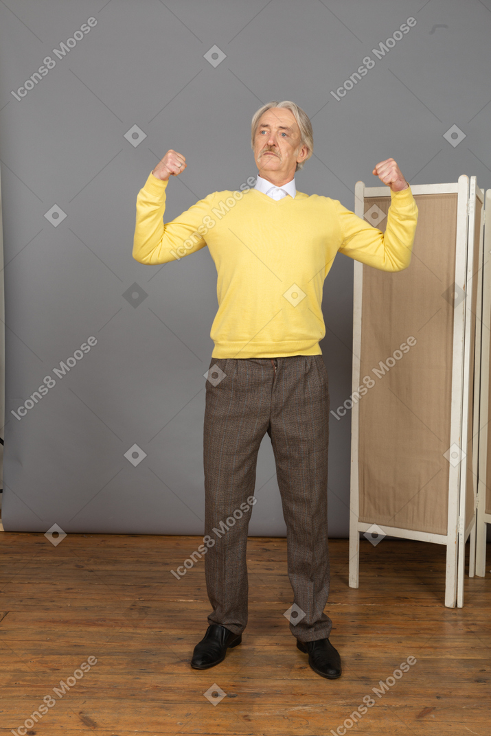 Front view of a strong old man demonstrating his strength