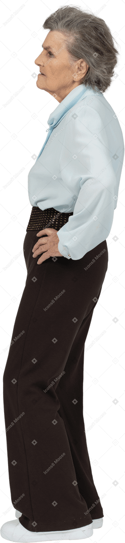 一件淡蓝色上衣和黑色长裤的老妇人的侧视图