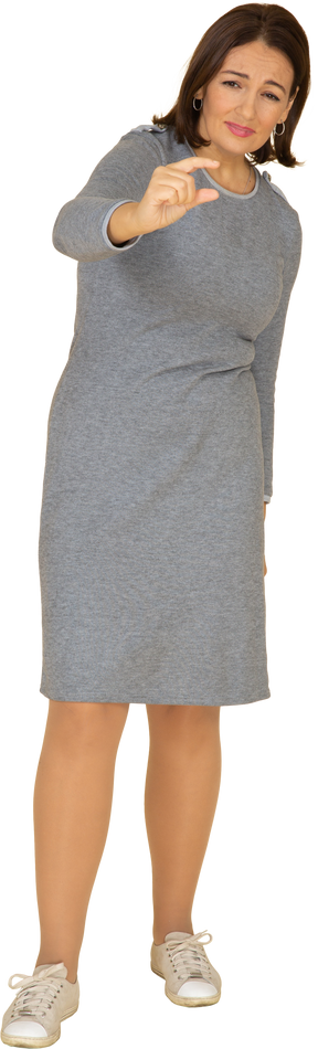 Vista frontal de uma mulher em um vestido cinza mostrando um tamanho pequeno de algo