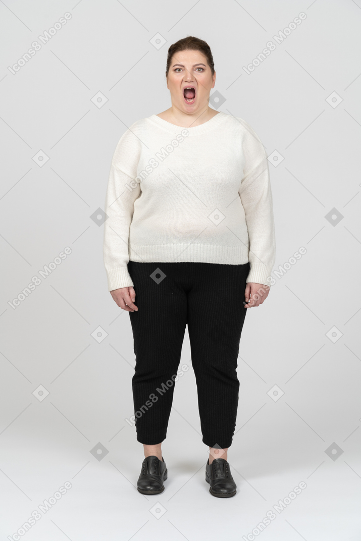 Extremely surprised plump woman in casual clothes looking at camera