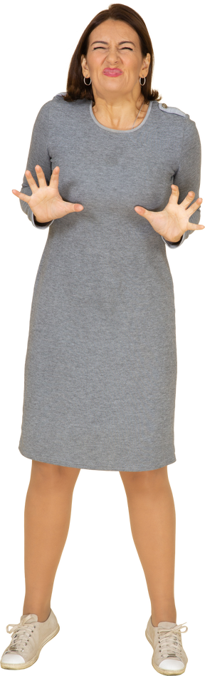 Vue de face d'une femme en robe grise faisant des gestes
