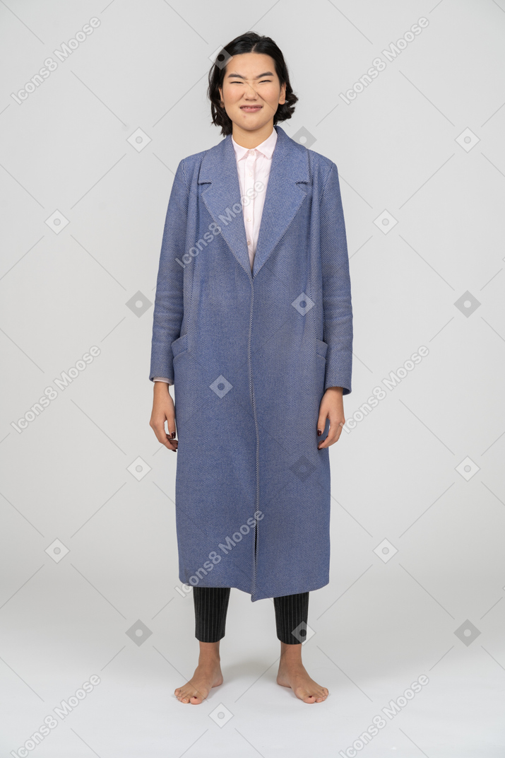 Vista frontale di una donna disgustata in cappotto blu