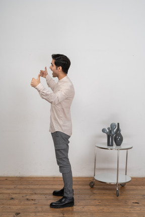 Vista lateral de um homem feliz em roupas casuais gesticulando