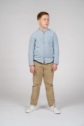 Front view of a cute boy in casual clothes looking aside