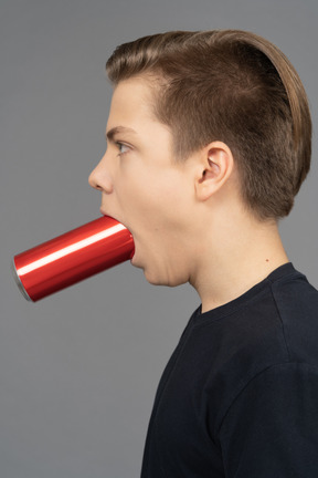 Vue latérale d'un homme avec une boîte rouge dans sa bouche