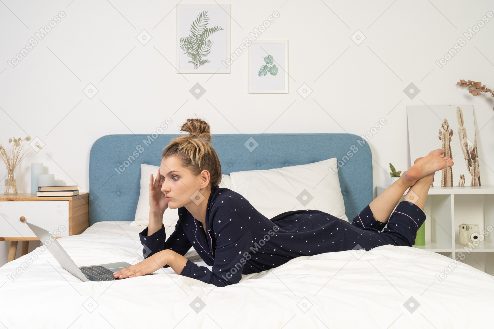 Side view of a baffled young female laying in bed with her laptop