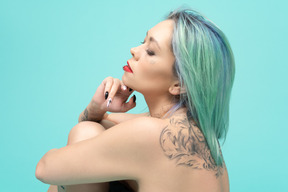 Close-up of a tattooed caucasian female over turquoise background