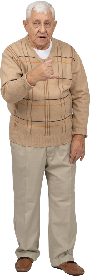 Vista frontal de un anciano con ropa informal que muestra el puño cerrado