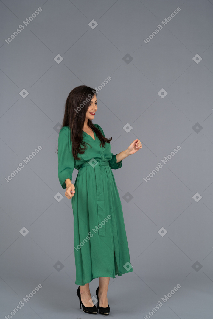 緑のドレスを着た笑顔の若い女性の4分の3のビュー