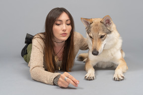 Joven mujer acostada con un perro de raza pura