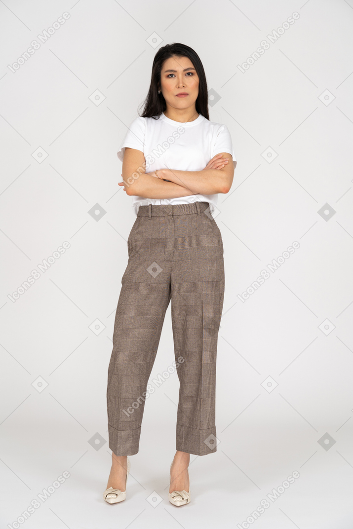 Front view of a young woman in breeches crossing hand