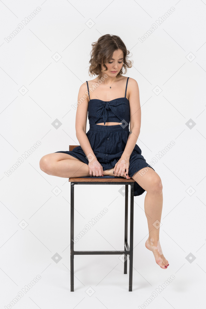 Triste chica delgada sentada en la silla de la barra