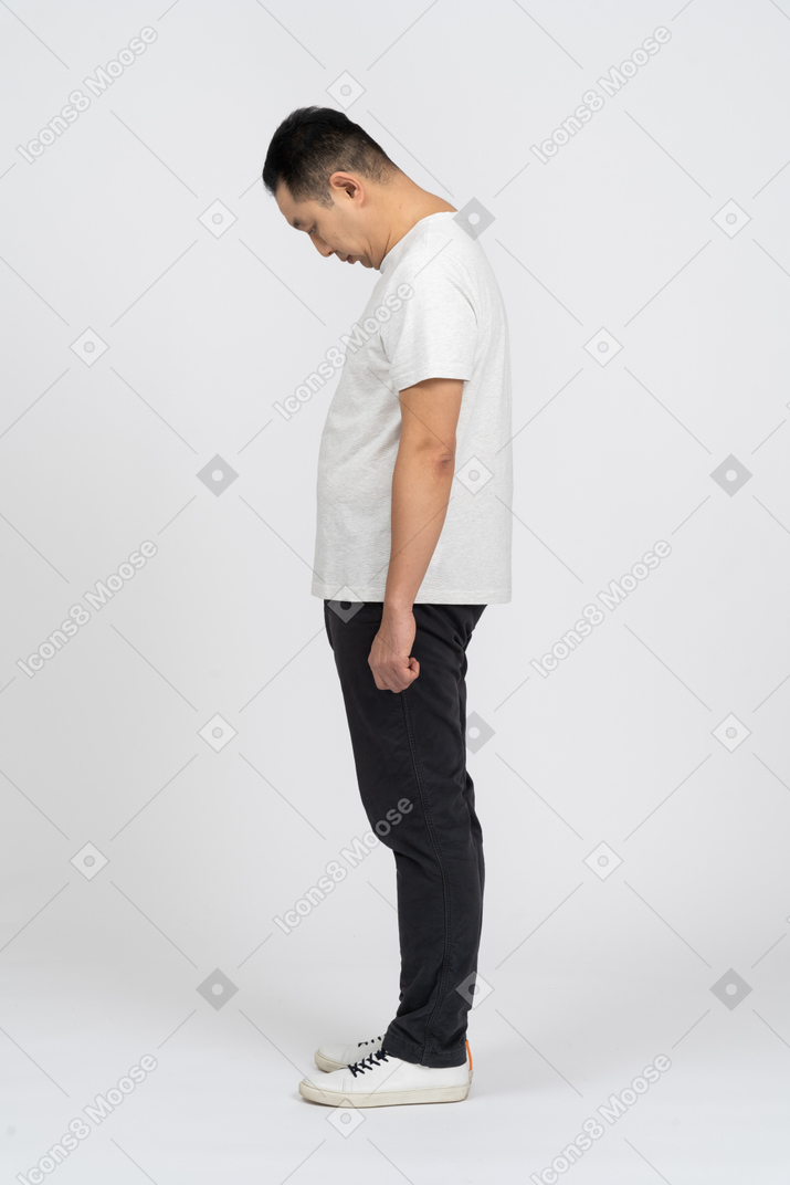 Side view of a man in casual clothes bending head down