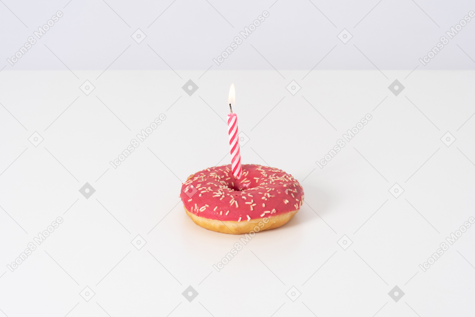 Pink donut with a candle on a white background