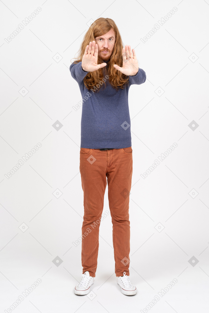 一个穿着休闲服的年轻人的正面图，双臂伸展，看着相机
