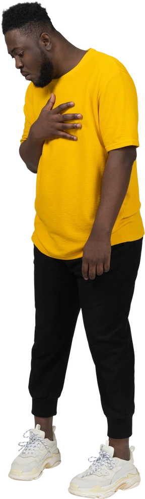 Three-quarter view of a surprised young dark-skinned man in yellow t-shirt touching chest