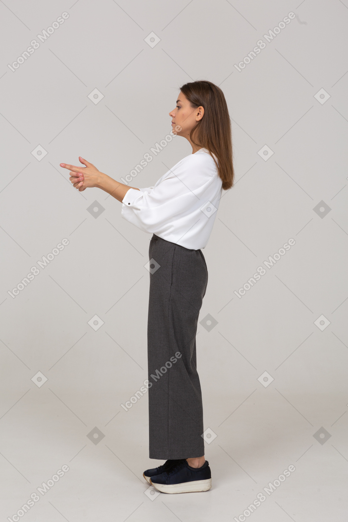 Side view of a young lady in office clothing making a shot