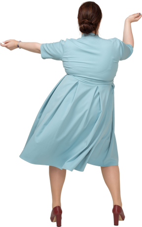 Вид сзади женщины в синем платье танцуют