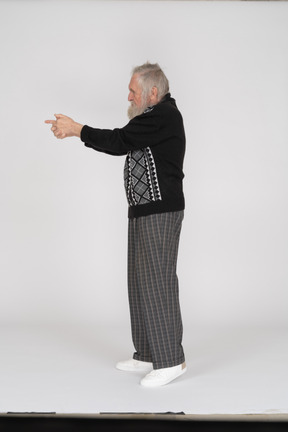Side view of old man aiming with finger gun