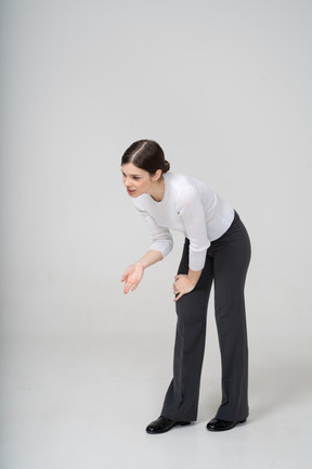 Front view of a young woman in suit bending down and arguing with someone