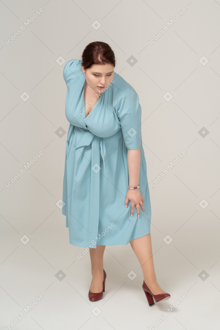 Front view of a woman in blue dress bending down