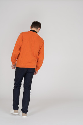 Joven en sudadera naranja de pie