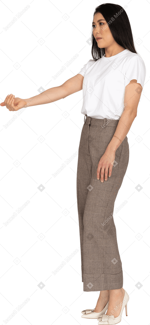 Dreiviertelansicht einer jungen dame in reithose und t-shirt, die ihre hand ausstreckt
