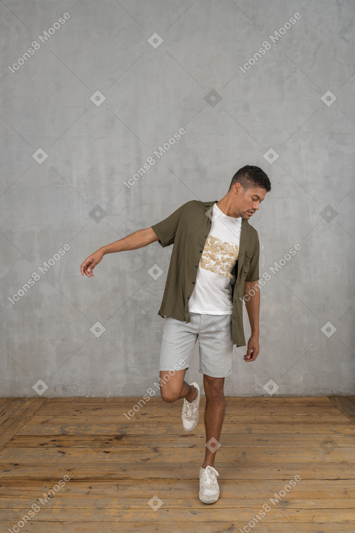 Uomo in piedi su una gamba sola con il braccio alzato