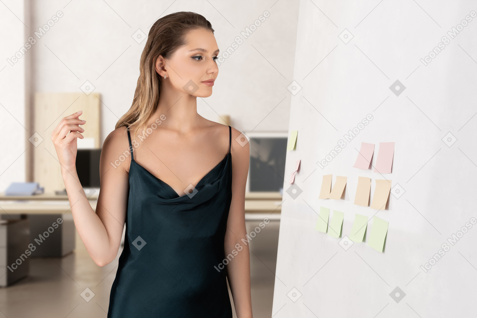A woman standing next to a white wall with sticky notes