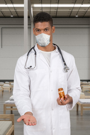 A man in a white lab coat holding a bottle of medicine